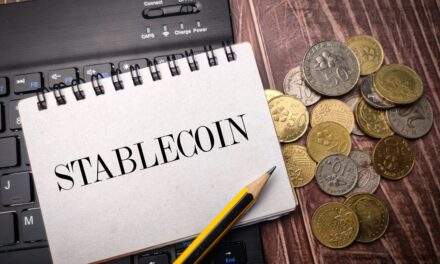 Notebook with Stablecoin written and various coins on desk