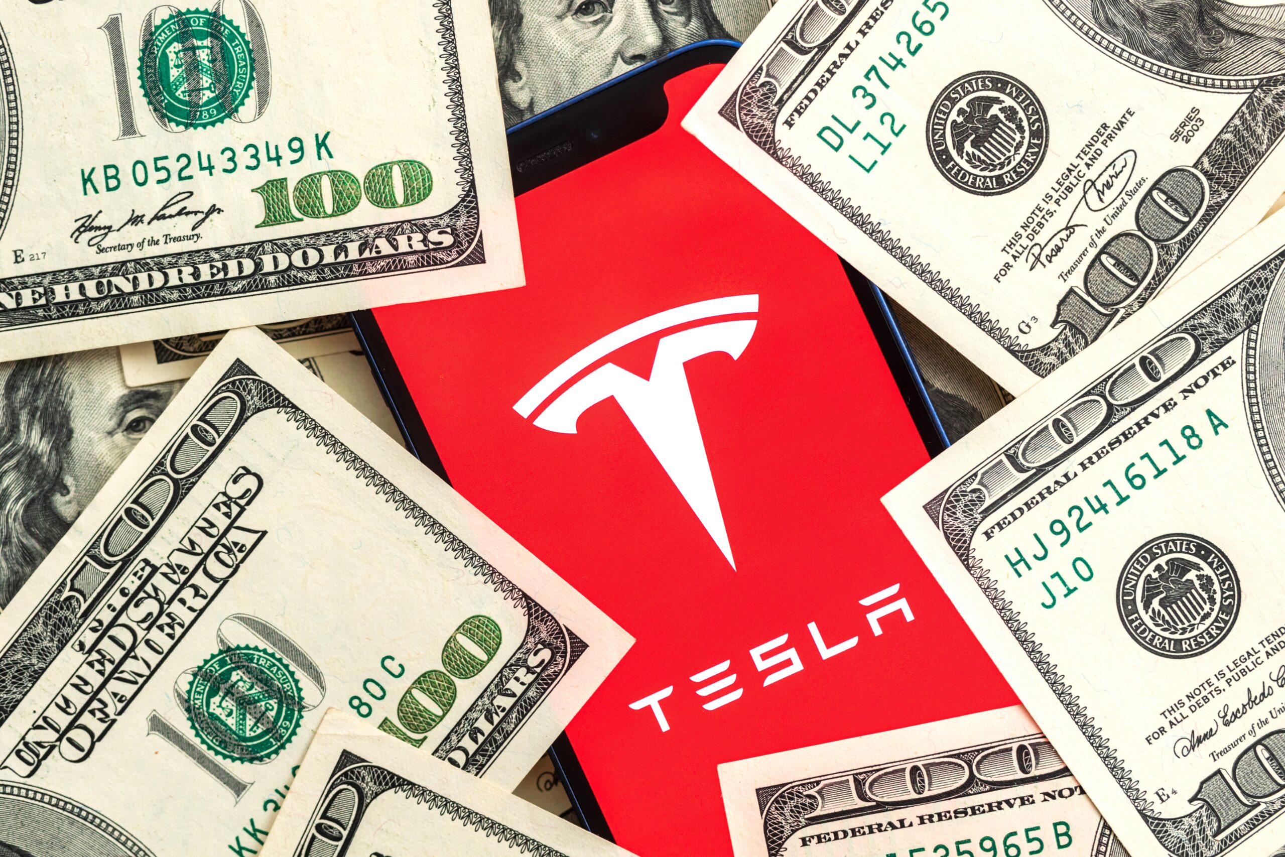 Tesla phone app surrounded by money
